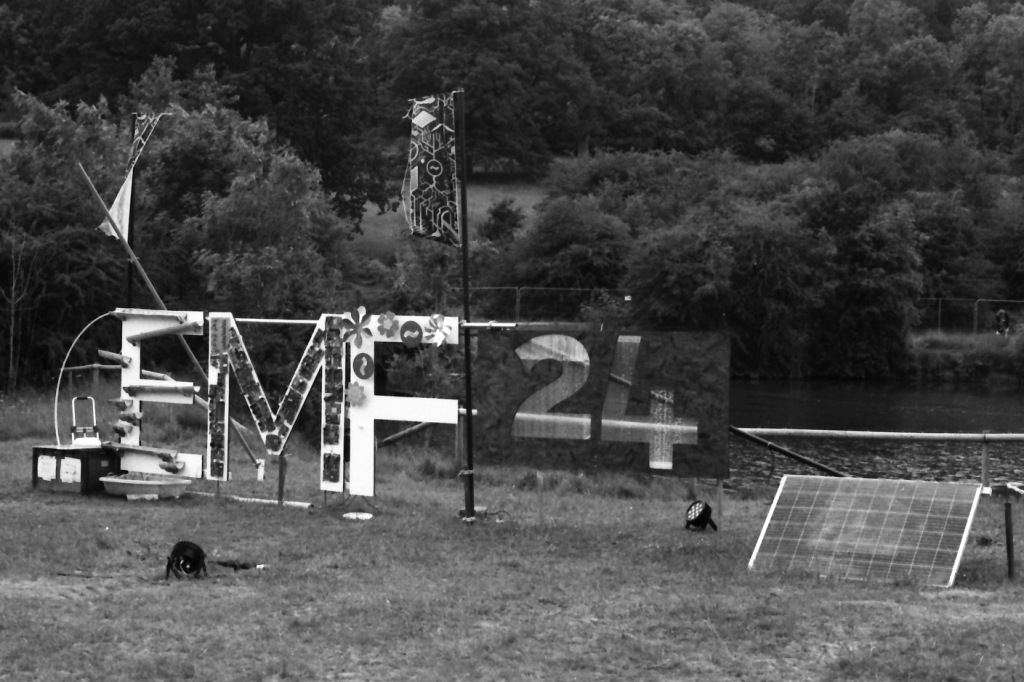 The EMF 2024 sign in daytime, on black-and-white film.